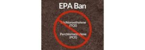 Text reading "EPA Ban" at the top with "Trichloroethylene (TCE)" and "Perchloroethylene (PCE)" inside a red circle with a slash through it, indicating prohibition. Background is textured dark brown.