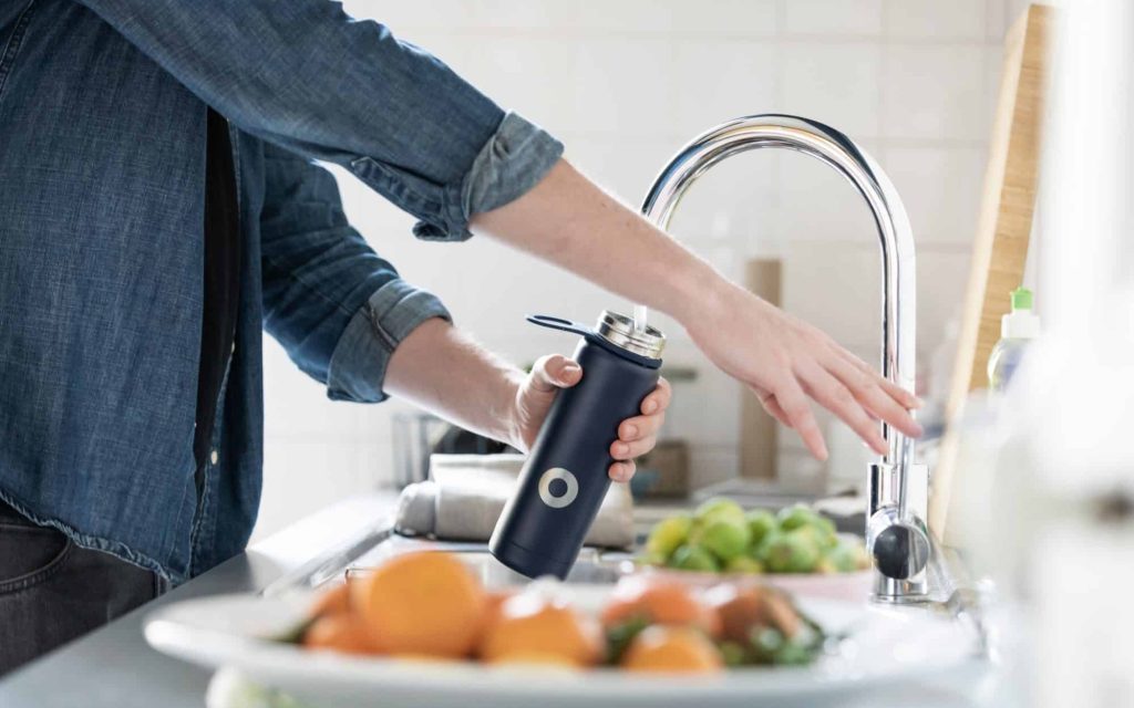 Man filling water bottle from the faucet